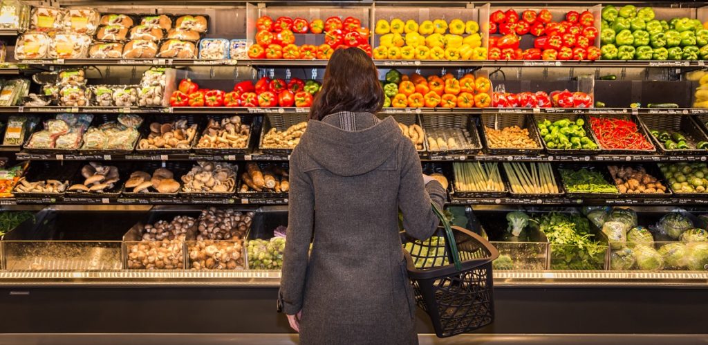 woman looking at fresh produce at the grocery store