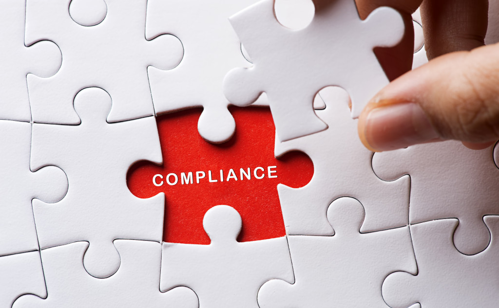 white puzzle piece about to cover the word compliance in a red space