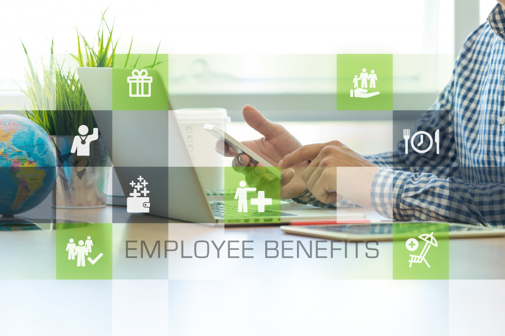 employee benefits graphics over employee using phone and laptop to work